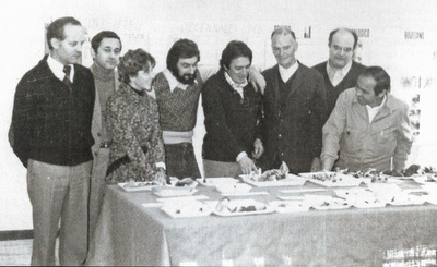 Vecchia foto in bianco e nero con i primi soci dell'Associazione, davanti a un tavolo con vari esemplari di funghi diversi raccolti da poco