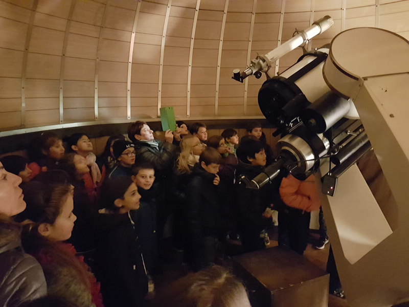 Una classe in visita alla Specola, tutti radunati intorno ai telescopi