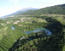 Vista aerea di un meandro di Roccasparvera, con il lago e la diga che lo sbarra, sullo sfondo